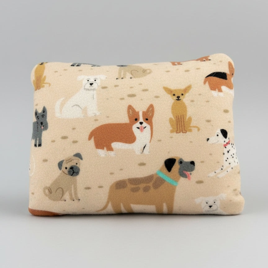 Beige heating pad with cartoon dog illustrations on a black background