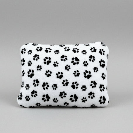 A white heating pad with black paw-prints